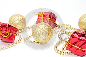 Christmas golden balls and gifts in red packaging tied by a chain on a white background