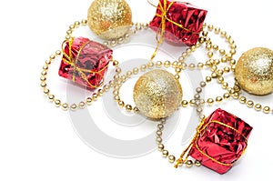 Christmas golden balls and gifts in red packaging tied by a chain on a white background