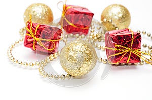 Christmas golden balls and gifts in red packaging tied by a chain on a white background