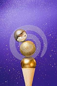Christmas golden baubles in ice cream cone on veri peri magic background. winter New Year card