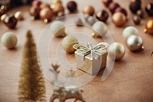 Christmas golden gift box on background of glitter tree and rein