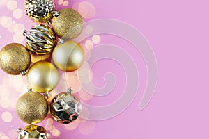 Christmas golden ornaments on pink background. Christmas decoration. Christmas card