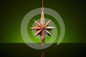 Christmas golden star ornament over green background