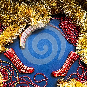 Christmas golden tinsel, red garland and socks on dark blue background. Happy New Year Banner, Merry Christmas. Xmas