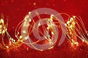 Christmas. Golden xmas lights wire on red background