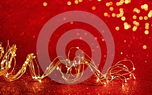 Christmas. Golden xmas lights wire on red background