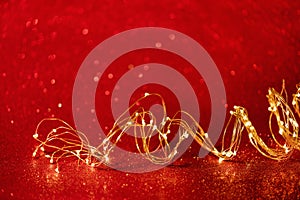 Christmas. Golden xmas lights wire on red background
