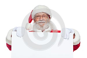 Christmas. Good Santa Claus in white gloves holds a blank white cardboard. Place for advertising, for text, empty space photo