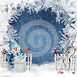 Christmas greeting background with a snowman near the fence and bullfinches on the branches of a tree