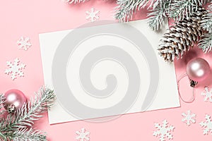 Christmas greeting card with empty blank sheet, fir tree and decorations on pink.
