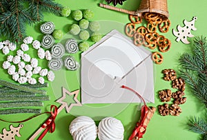 christmas greeting card with fir branches, gift boxes, decorations, ginger cookie and pine cones on rustic wooden table covered wi