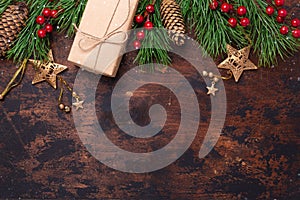 Christmas greeting card with fir tree branch, gifts and present box. Wooden background. Top view Copy space