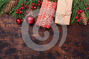 Christmas greeting card with fir tree branch, gifts and present box. Wooden background. Top view Copy space. Snow effect