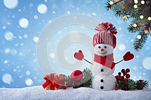 Christmas greeting card with funny snowman, gift box and fir tree branches in winter scenery. Snowy background