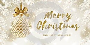 Christmas greeting card. Glitter gold brush calligraphy greeting and patterned golden bauble with bow hanging on a christmas tree.