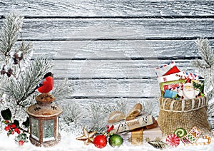 Christmas greeting card with space for text, with gifts, a lantern, a bullfinch, a bag of letters and sweets on a snowy wooden boa