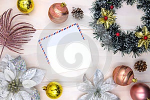 Christmas greeting top view composition. Blank postcard with air mail envelope. Christmas tree ball and wreath