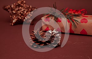 Christmas greetings with a beautiful gift box decorated with fir branches and with two cones