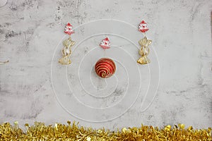 Christmas grey background with golden candy and big red baubles. golden tinsel bottom. Space for text