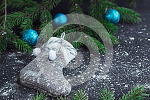 Christmas grey stocking on snowbound black background with blue