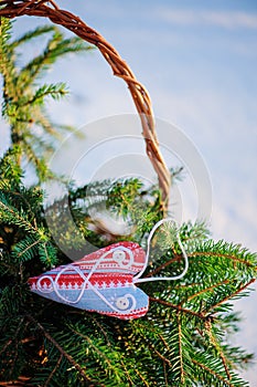 Christmas handmade blue and red fabric heart decorations and gift bag with fir branches in snowy winter, selective focus