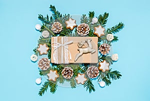 Christmas handmade gift box and holiday decoration: reindeer, conifer tree branches, pine cones, cinnamon star cookies, baubles