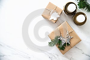 Christmas handmade gift boxes on white marble background top view. Merry Christmas greeting card, frame. Winter xmas holiday theme