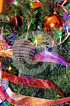Christmas hanging decorations on fir tree. Decorated Christmas tree. Fir branch with Christmas decorations surrounded by lights