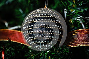 Christmas hanging decorations on fir tree. Decorated Christmas tree.  Fir branches with black Christmas ball