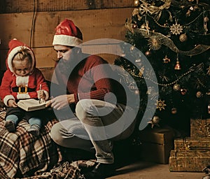 Christmas happy child and father read book.