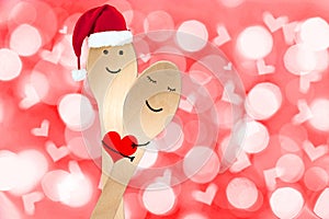 Christmas happy couple concept, smiley painted on spoons, holiday red background with blurred lights