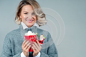 Christmas and New Year. Woman in in knitted sweater is drinking hot coffee.