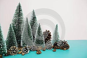 Christmas and happy new year holidays background with Christmas trees and pine cone on pink and blue background