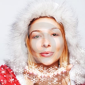 Christmas - happy woman blowing snow flakes