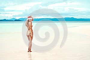 Christmas hat, beach and woman with a smile, vacation and summer getaway with happiness, tropical island and relax