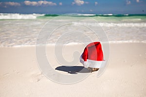 Christmas hat at coconut on a white sandy beach