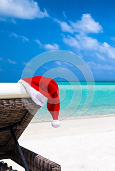 Christmas hat on sun chair at tropical beach