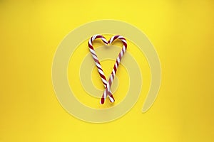 Christmas heart made of sweets on a yellow background. Flat lay, place for text