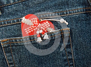 Christmas heart tucked into denim trouser pocket. photo