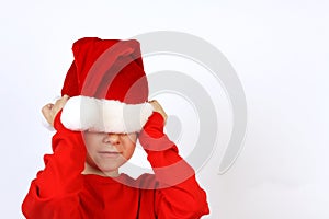 Christmas helper child put on Santas Claus hat on head front of white background