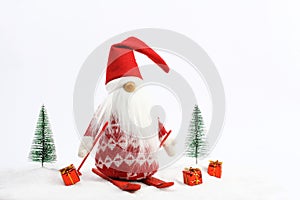 Christmas helper (elf) skiing on snow next two snowy trees and three gifts Red and white colors