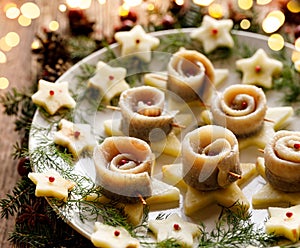 Christmas herrings fillets on a ceramic plate close-up.