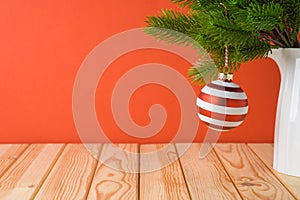 Christmas holiday background with bauble decoration and fir tree branches on wooden table