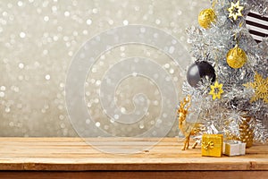 Christmas holiday background with Christmas tree and decorations on wooden table. Black, golden and silver ornaments photo