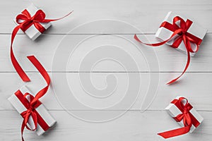 Christmas holiday background composition. Christmas gifts with red ribbon on white wooden table. Xmas and happy new year card.