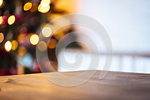 Christmas holiday background with empty rustic table and the bokeh of the living room with the Christmas tree