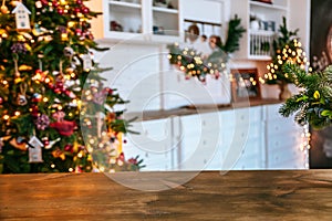 Christmas holiday background with empty rustic table and the bokeh of the living room with the Christmas tree on the second plan