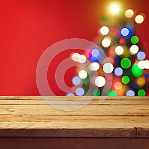 Christmas holiday background with empty wooden deck table over Christmas tree bokeh. Ready for product montage