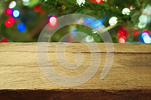 Christmas holiday background with empty wooden table over Christmas tree bokeh. Product montage display or mock up design