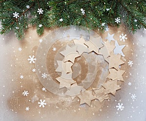 Christmas holiday background with fir tree branches and Golden Christmas wreath from stars shape on defocused background..Top view